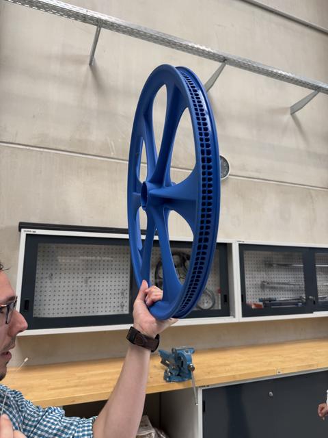 Kompozytowe koło trzymane w dłoni podczas zwiedzania laboratorium