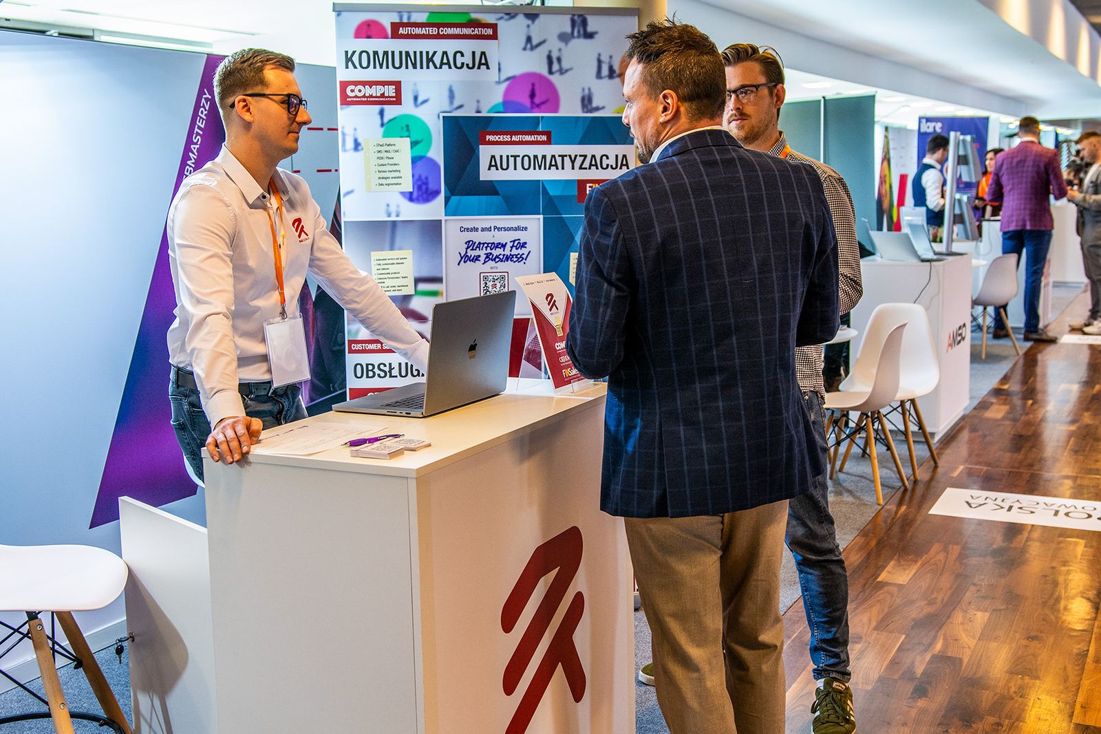 Stoisko RAE na targach IT FUTURE EXPO — rozmowa z odwiedzającymi przy laptopie